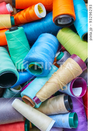 Spools of orange, light blue, sky blue, tan, white, purple, red and light purple thread 93296293