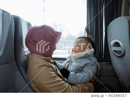 smiling mother and toddler sitting inside the bus 93298357