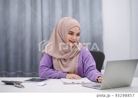 Attractive muslim woman brown hijab working at her home. 93298857