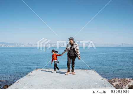 father and daughter walking together on the jetty next to marmara sea 93298982