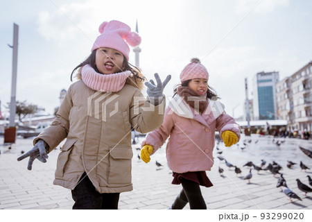 two little girl playing chasing a bird in istanbul taksim 93299020