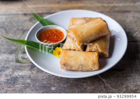 Fried spring rolls on a white plate and spicy sauce Fried spring rolls on a white plate and spicy sauce 93299954