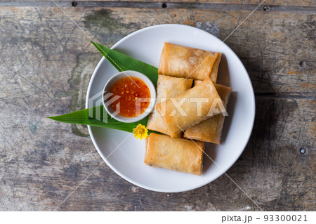 Fried spring rolls on a white plate and spicy sauce Fried spring rolls on a white plate and spicy sauce 93300021