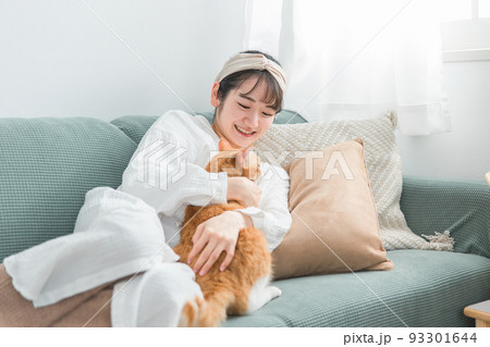ソファでペットの猫と遊ぶ日本人女性 93301644