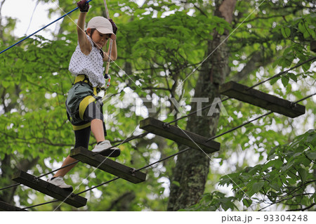 木の上のアスレチックで遊ぶ女子小学生 (7歳) 93304248