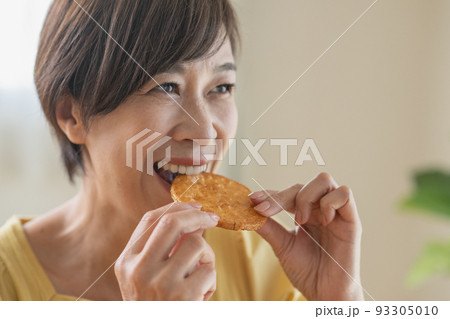 煎餅を食べるシニア女性 93305010