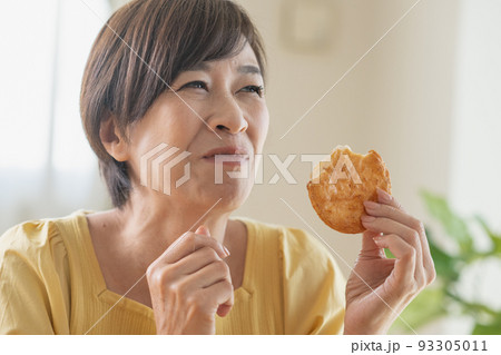 煎餅を食べるミドル女性 93305011