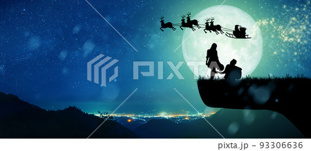 Silhouette of Santa Claus get a move to ride on their reindeer over full moon at night Christmas. Enjoying couple dancing under the full moon. 93306636