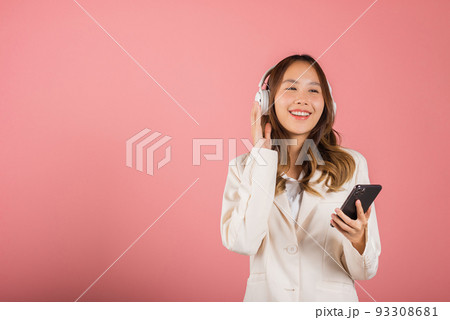 woman has fun she's listening music with headphones in smartphone app woman has fun she's listening music with headphones in smartphone app 93308681