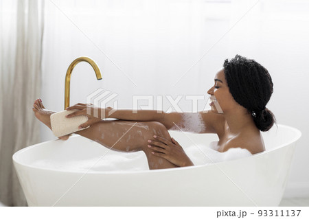 Beautiful Black Woman Taking Foamy Bath And Using Body Sponge Beautiful Black Woman Taking Foamy Bath And Using Body Sponge 93311137