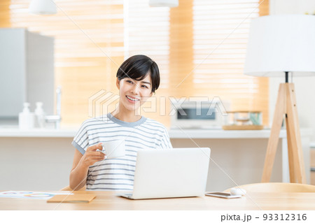 リビングでテレワーク中に休憩する女性 93312316
