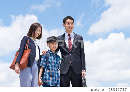 青空のもと並んで遠くを見つめる3人家族 青空のもと並んで遠くを見つめる3人家族 93312757