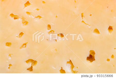 A piece of Russian cheese with holes close-up. A piece of Russian cheese with holes close-up. 93315666