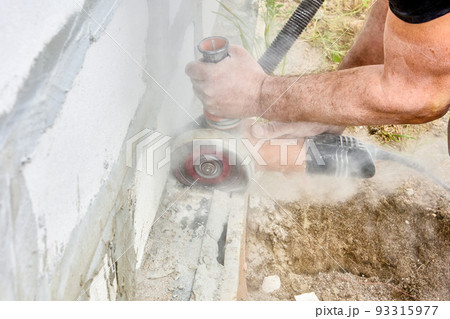 Cutting masonry with angle grinder power tool for cut concrete with silicon carbide wheels. Cutting masonry with angle grinder power tool for cut concrete with silicon carbide wheels. 93315977