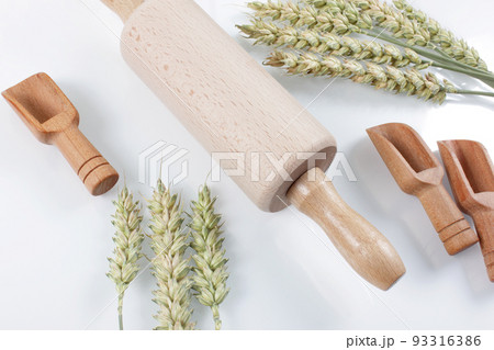 Rolling pin with wheat and spoons isolated on white background.  93316386