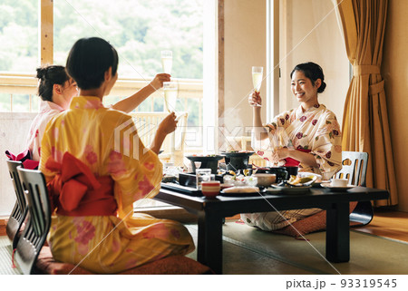 旅先の旅館でご飯を食べる女性 93319545