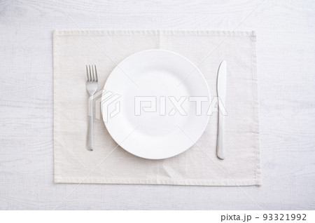 シンプルな白い皿とフォークとナイフ 93321992
