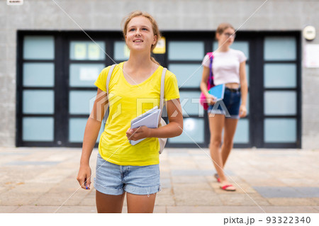 Cute teen girl walking down street to school 93322340