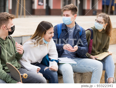 Teenagers in face masks talking outdoors 93322341