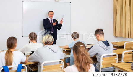 Adult teacher is giving lecture for students in class Adult teacher is giving lecture for students in class 93322709