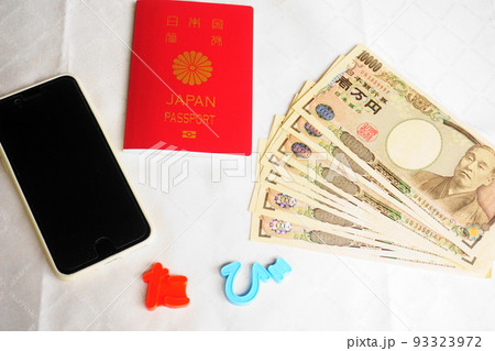 白を背景に置かれたパスポート、一万円札、スマートフォン 白を背景に置かれたパスポート、一万円札、スマートフォン 93323972