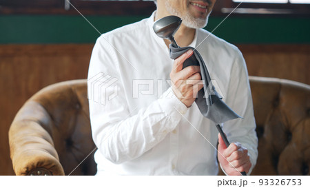 ゴルフクラブを磨く中高年男性 93326753