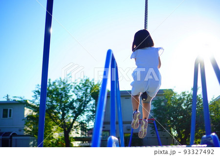 公園のターザンロープで遊んでいる小学生の女の子の後ろ姿 公園のターザンロープで遊んでいる小学生の女の子の後ろ姿 93327492