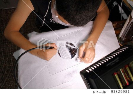 夏休みの作品にガラスエッチングを制作する少年 93329981