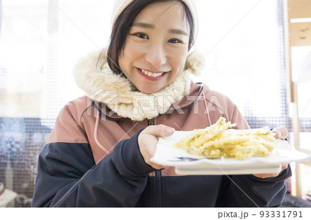 わかさぎの天ぷらを見せる若い女性 93331791