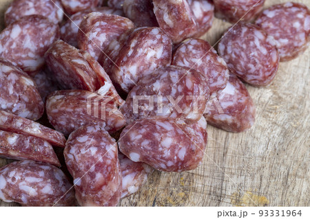 sliced thin sausage with bacon on a wooden dish 93331964