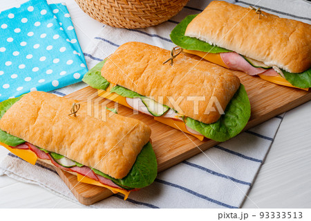 Sandwich with ham and cheese on wooden board Sandwich with ham and cheese on wooden board 93333513