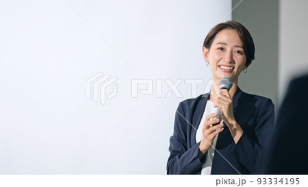 登壇する女性と聴衆　セミナー　プレゼンテーション 93334195