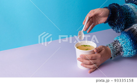 Eating a Chicken broth soup from takeaway cup Eating a Chicken broth soup from takeaway cup 93335158