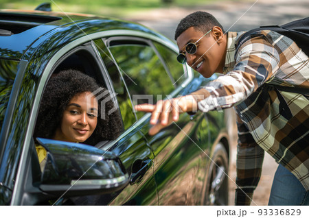 African american man in plaid shirt asking a female driver to take him to the city 93336829