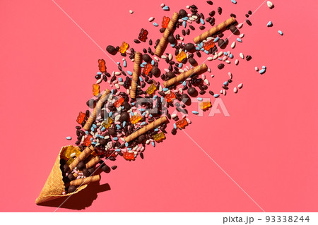 A variety of delicious sweets explode from the waffle cone, view from above. From left to the right direction A variety of delicious sweets explode from the waffle cone, view from above. From left to the right direction 93338244