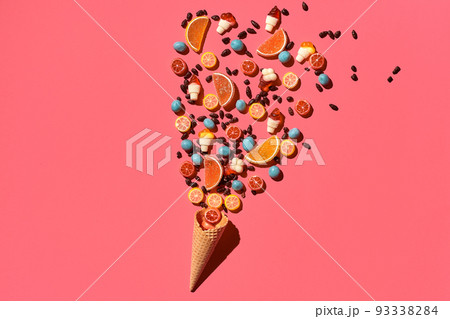 A variety of delicious sweets explode from the waffle cone, view from above. From left to the right direction 93338284