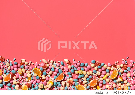 Various sweets, candys are palced on the photo on the coral background Various sweets, candys are palced on the photo on the coral background 93338327