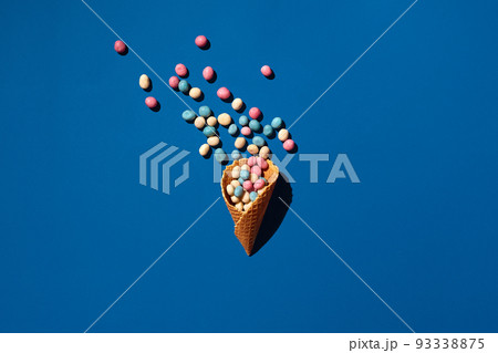 An image of a heap of dragee sweets that is sprinkled from a waffle cone An image of a heap of dragee sweets that is sprinkled from a waffle cone 93338875