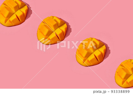 Colorful fruit pattern of fresh juicy cutted mango on coral pink background, top view 93338899