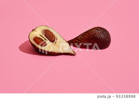 Close up high quality image of cutted salacca halves, fruit composition on pink pastel 93338998