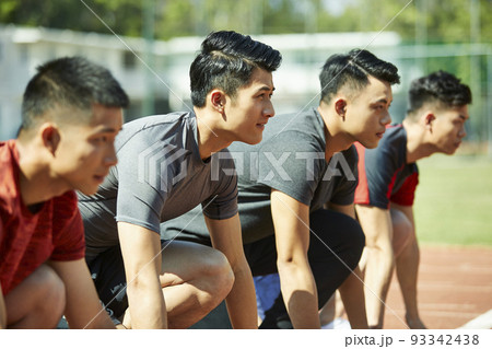 young asian track and field athletes sprinters setting on starting line 93342438