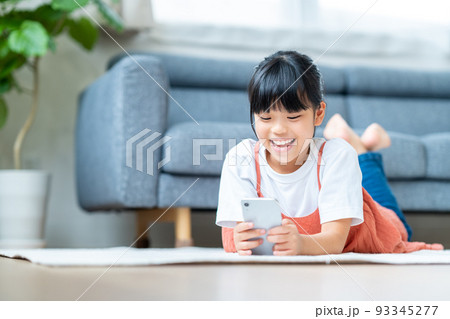 リビングでスマホをする小学生の女の子 93345277