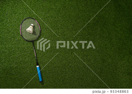 Badminton racket and shuttlecock on green grass background. Badminton racket and shuttlecock on green grass background. 93348863