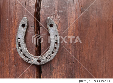 Old horseshoe on wooden wall background. Farm authentic entourage. Good luck, safety. Protect from breaking apart, failure misfortunes. Superstitions, beliefs. Problem solution. Property insurance Old horseshoe on wooden wall background. Farm authentic entourage. Good luck, safety. Protect from breaking apart, failure misfortunes. Superstitions, beliefs. Problem solution. Property insurance 93349213