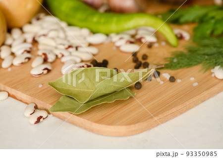 Vegetables and spices on a wooden cutting board in the kitchen. Vegetables and spices on a wooden cutting board in the kitchen. 93350985