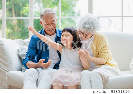 リビングでくつろぐシニア夫婦と孫 リビングでくつろぐシニア夫婦と孫 93351310
