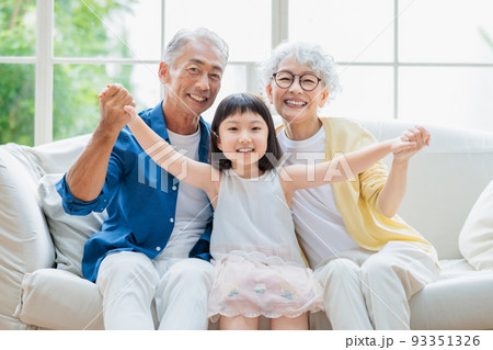 リビングでくつろぐシニア夫婦と孫 リビングでくつろぐシニア夫婦と孫 93351326