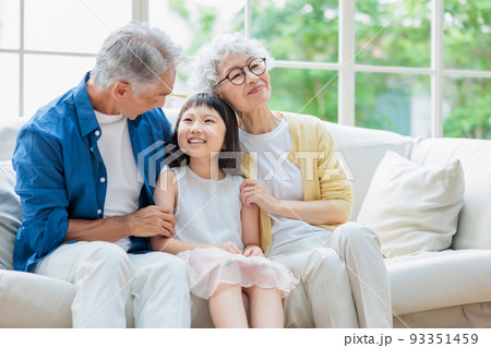 リビングでくつろぐシニア夫婦と孫 リビングでくつろぐシニア夫婦と孫 93351459