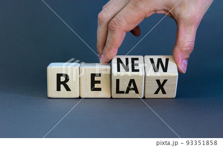 Relax and renew symbol. Businessman turns cubes and changes the word 'relax' to 'renew'. Beautiful grey table, grey background. Business, relax and renew concept. Copy space. 93351858