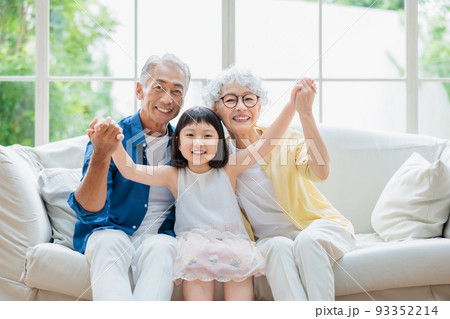 リビングでくつろぐシニア夫婦と孫 93352214
